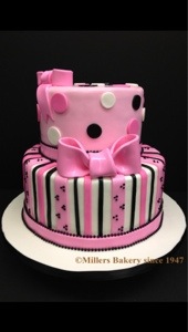 This Two Tiered Cake Has A Paris Inspired French Pink Pattern.Sides Has Striped Pattern And Polka Dots and French Pink Bows On Each Tier.