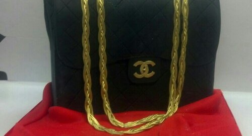 Black And Gold Gucci Pocketbook Set On A Satin Red Fondant Cloth Display.Whether it&#8217;s their favorite purse designer, or their favorite handbag in general this unique cake will definitely catch their eye. &#160;