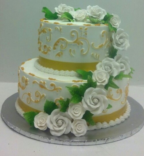 Two Tier Butter Cream With Hand Painted Gold Scroll High Lights With Elegant ,White Cascading Roses. The Top And Bottom Tiers Cumulate in Beautiful White Bouquets &#160;